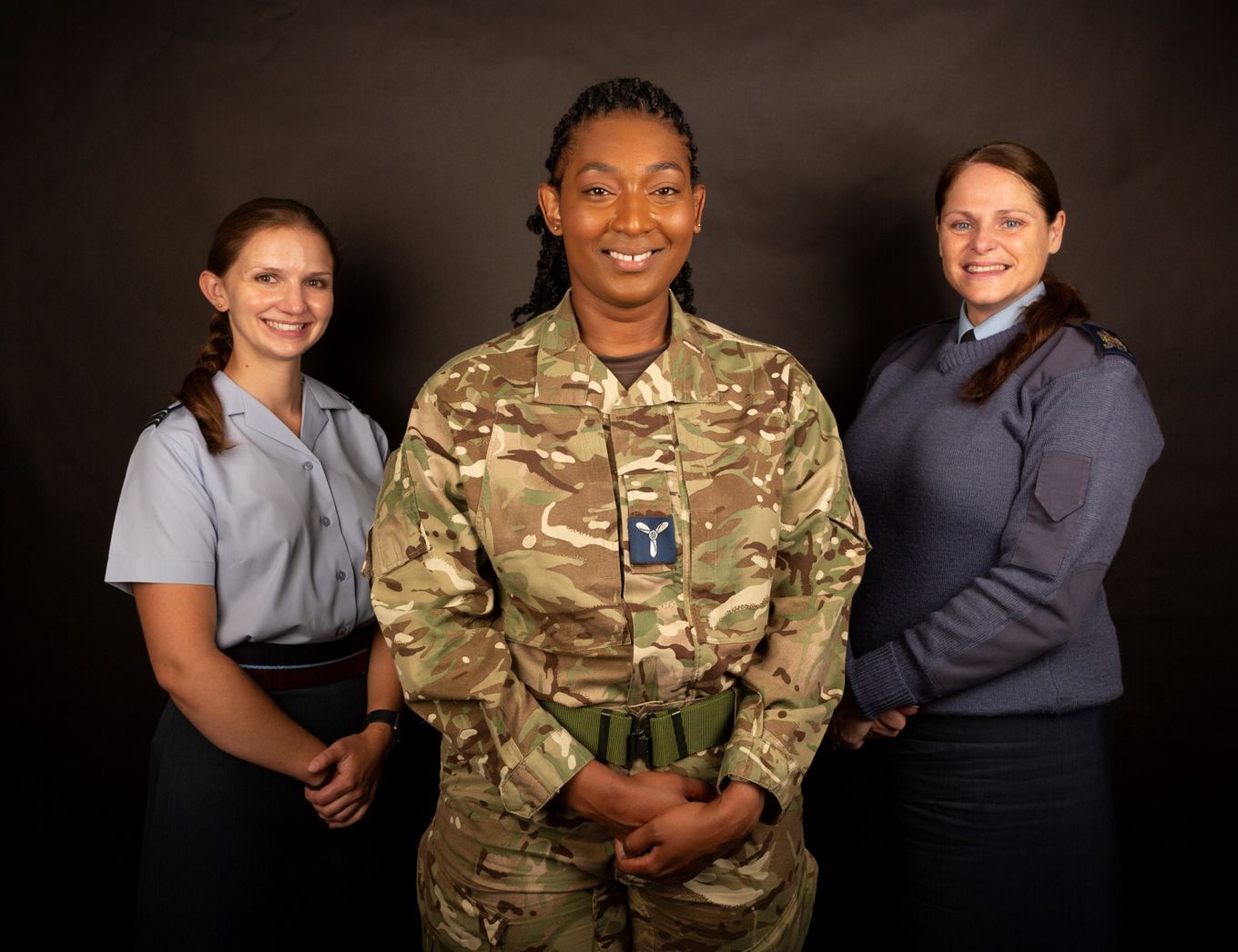 Three female personnel stand. 